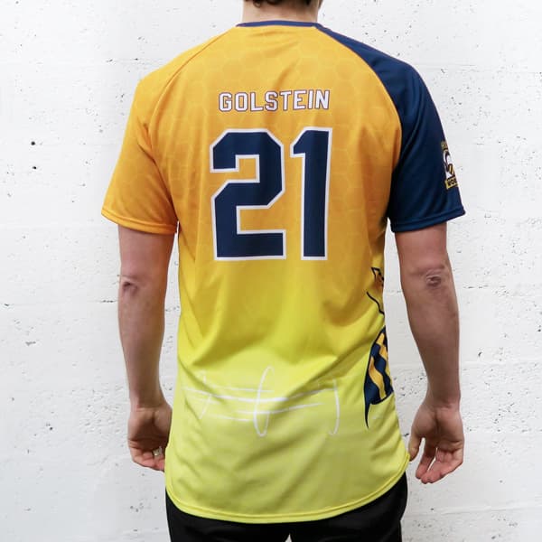 achterkant van man met nummer 21 geel verloop en blauwe raglan sportshirt