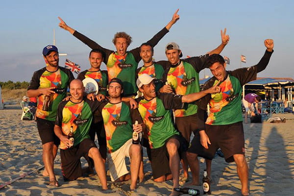 gelukkig sportteam op het strand bij zonsondergang met kleurrijke jerseys