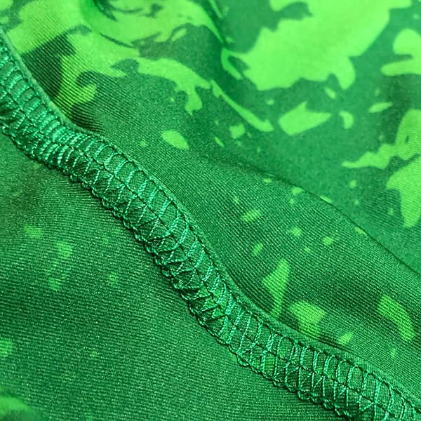 green fabric with green sewing stitches