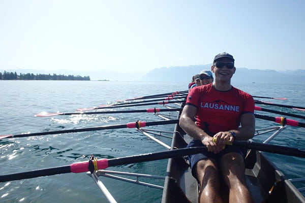 thumbnail sport rowers on lake wearing red compression tops with lausanne writing
