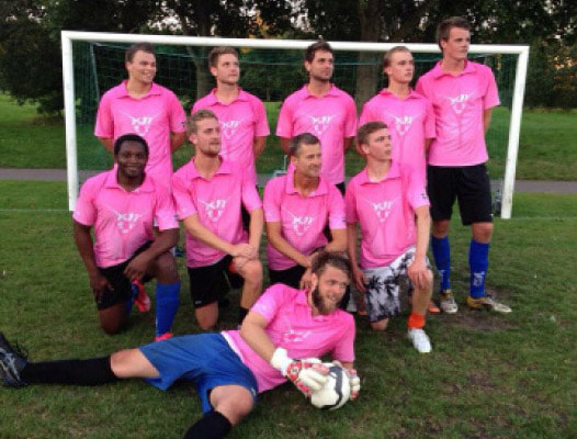 thumbnail team of football players posing in pink polo shirts
