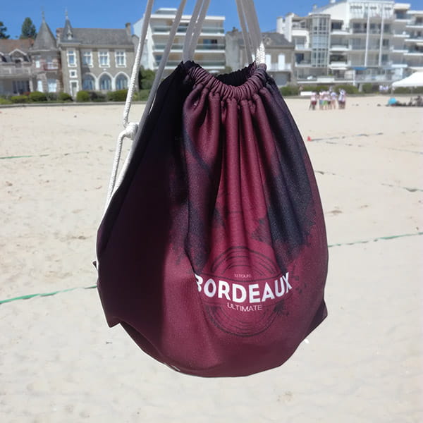 bordeaux drawstring bag hanging at the beach