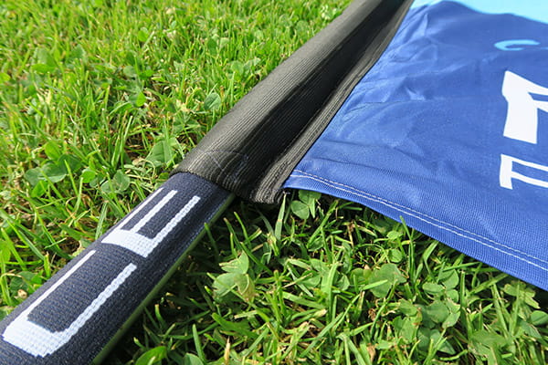 black scabbard and sewing stitches with grass background