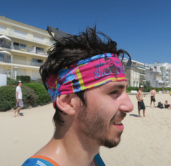 thumbnail right side view of head of man wearing a pink and blue headband at the beach