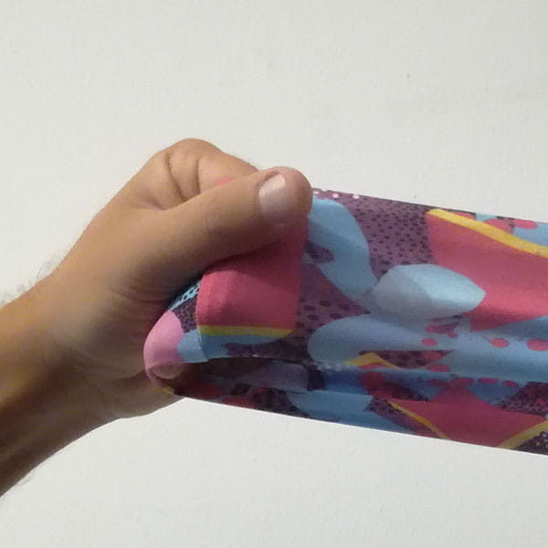 hand stretching a pink and light blue fabric