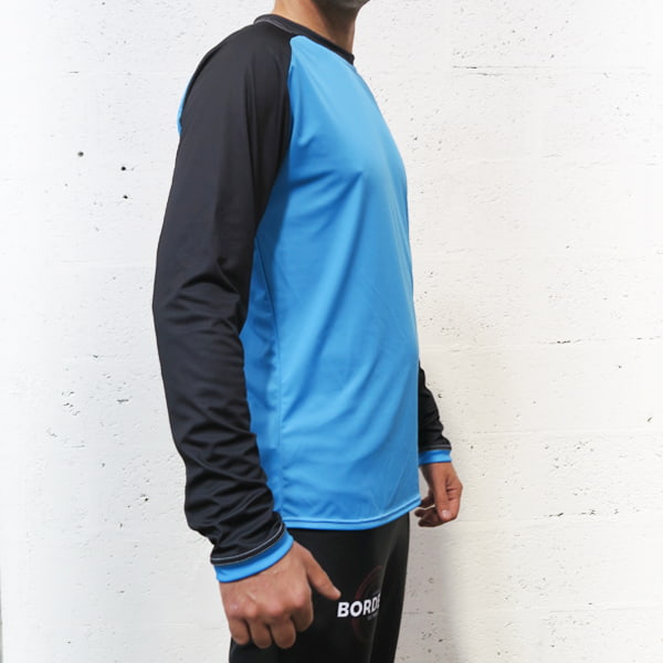 thumbnail side view of the torso of a man wearing a blue and black raglan longsleeved jersey