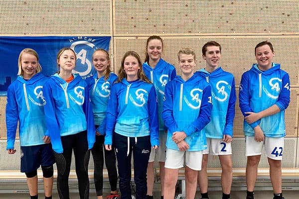 group of young people standing wearing blue sublimated hoodies