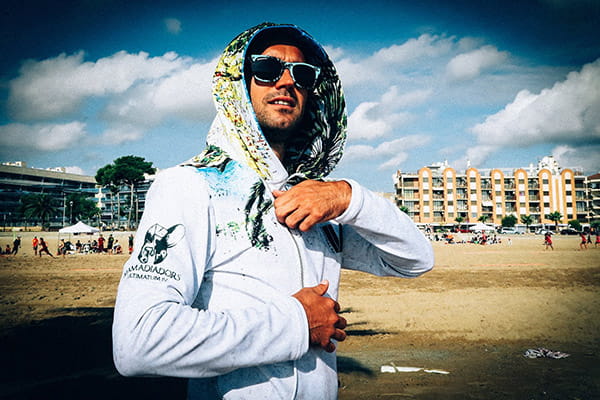 man at the beach with sunglasses wearing a white sublimated hoodie with hood up