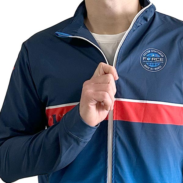 upper body of a smiling man wearing a sublimated blue jacket with a hoodie on