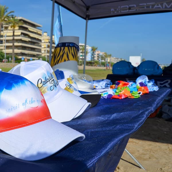 table with hats and other items on beach under a tent