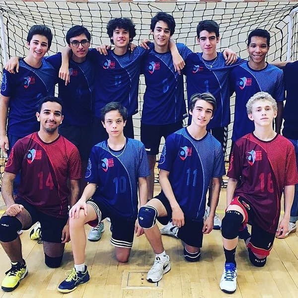 boys volleyball team in blue outfit libero in red