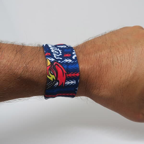 arm wearing a blue red wristband with rooster on white background