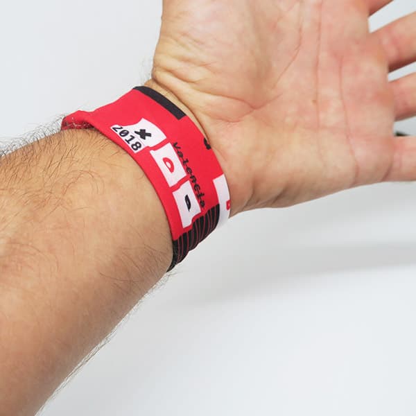 arm wearing white and red wristband on white background