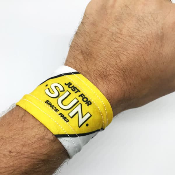 arm wearing white and yellow wristband on white background